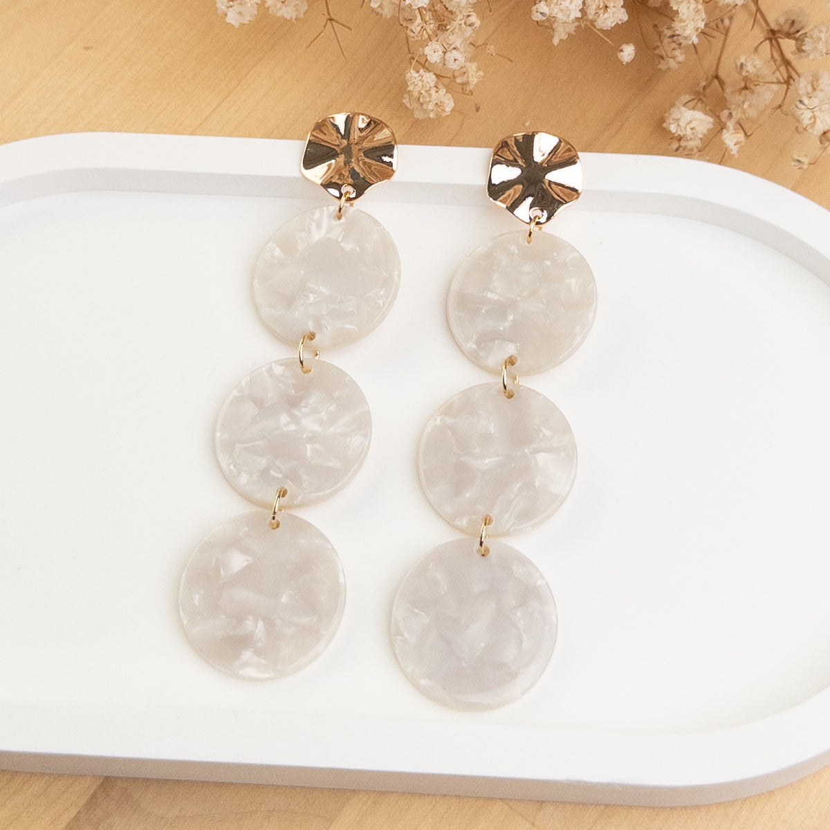 Boucles d'oreilles Léonore posées, trois disques blanc nacré sous une attache ronde dorée
